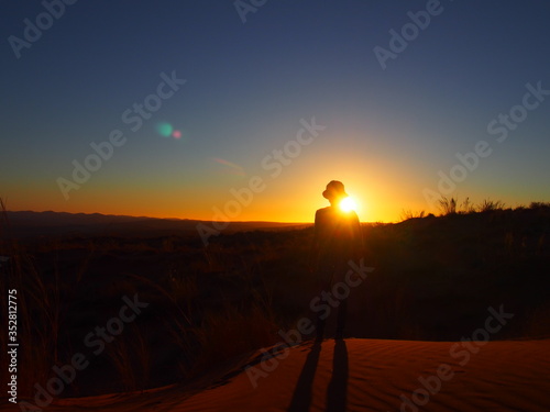 A woman standing on a Elim Dunes and a beautiful sunset, Namibia