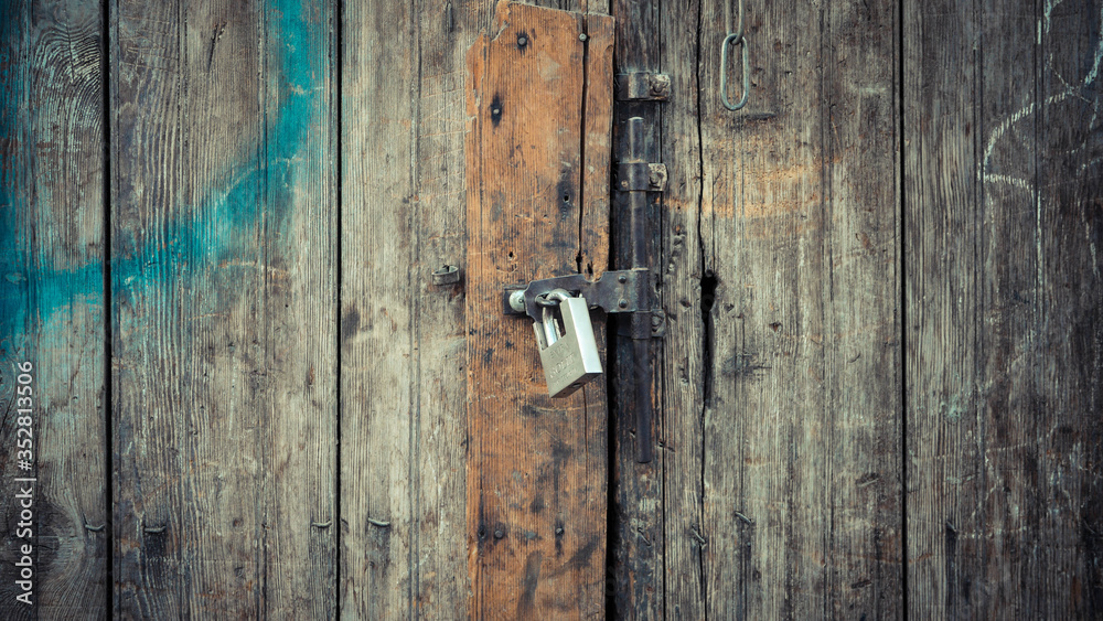 padlock locked on to wooden door with lines