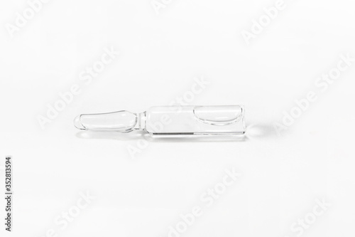 Medical glass ampoule vial with solution for injection on white background