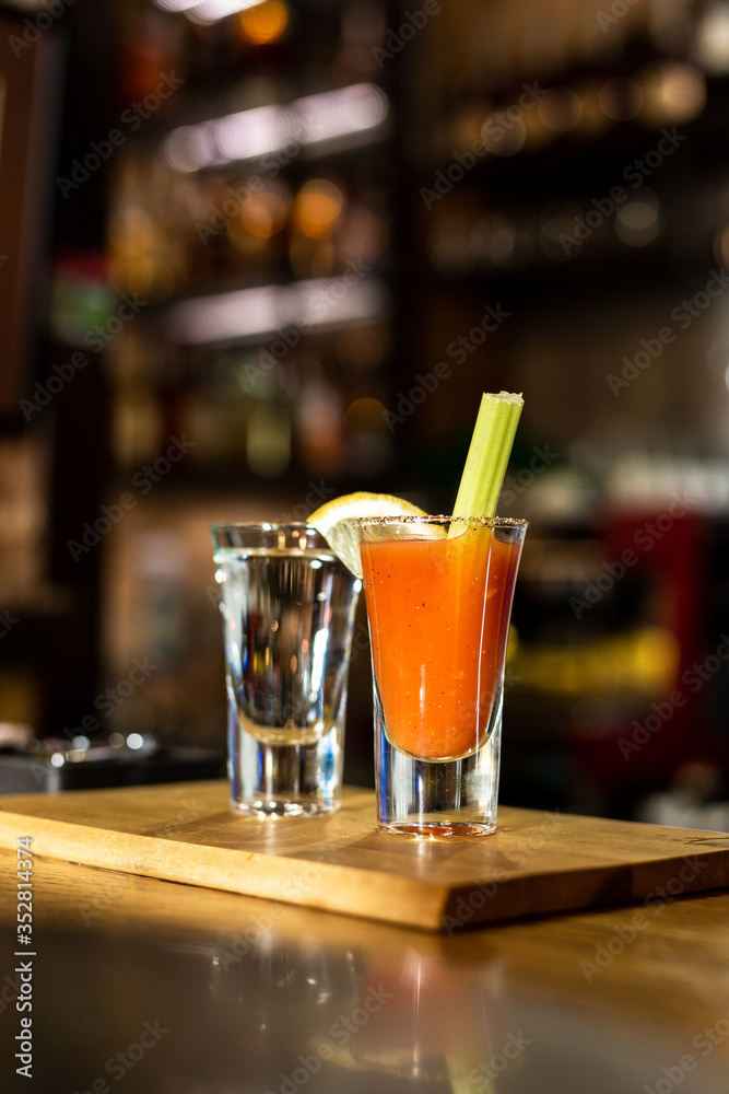 Cocktail in a glass with Tobasco and alcohol. Sambuca. A slice of lemon and celery. The interior of the bar. Cocktail in a glass with Tobasco and alcohol. Sambuca. A slice of lemon and celery. The interior of the bar.