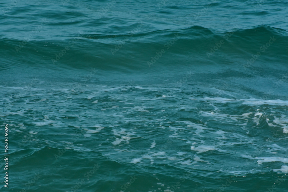 Blue sea That is a wave, because the strong wind causes the beautiful water to rise
