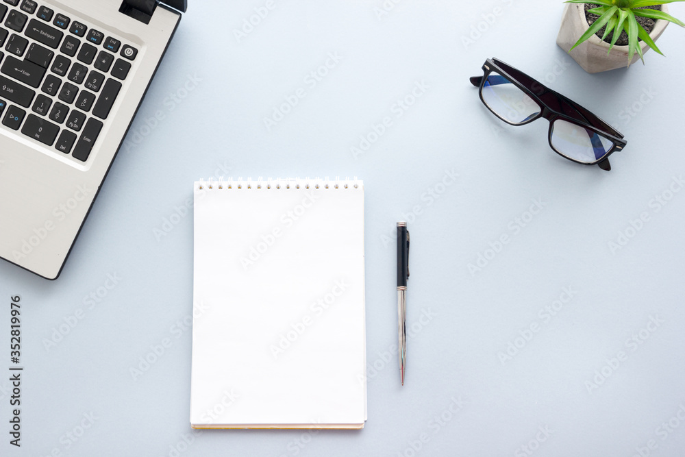 Blue desk office with laptop, smartphone and other work supplies with cup of coffee. Top view with copy space for input the text. Designer workspace on desk table essential elements on flat lay Blue desk office with laptop, smartphone and other work supplies with cup of coffee. Top view with copy space for input the text. Designer workspace on desk table essential elements on flat lay