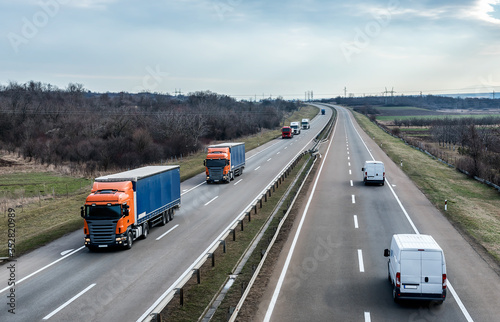 Highway Transportation traffic with Convoy of transportation trucks passing on a highway. Highway transportation concept with white lorry tracks  © Ivan