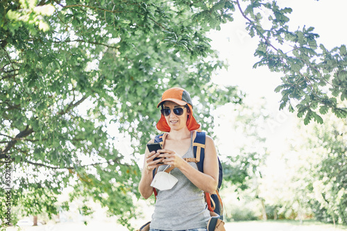 Woman chatting on her cell phone while hiking in Coronavirus times