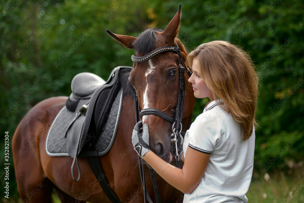 Obraz premium Beautiful young girl rider and her horse