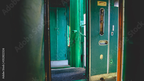 Obraz na plátně Toned image of open doors in corridor of vintage steam express trian