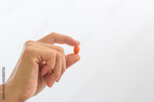 Pick up vitamin capsules to eat