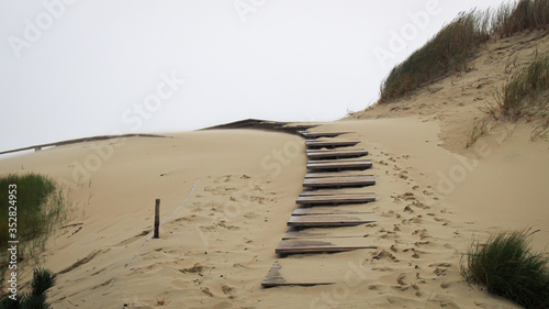 Wooden pathway at Curonian Spit sand dunes in Nida, Lithuania.