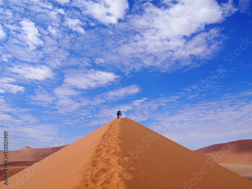 A woman barefoot up a beautiful sand Dune 45  Namibia
