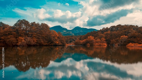 Trees, mountain and clouds reflected on the surface of the lake in autumn colors. Fukushima, Japan 