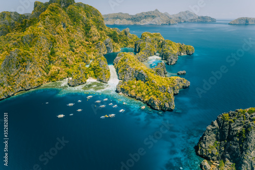 Palawan, Philippines aerial view of tropical Miniloc island. Tourism trip boats at big lagoon entrance. Natural scenery