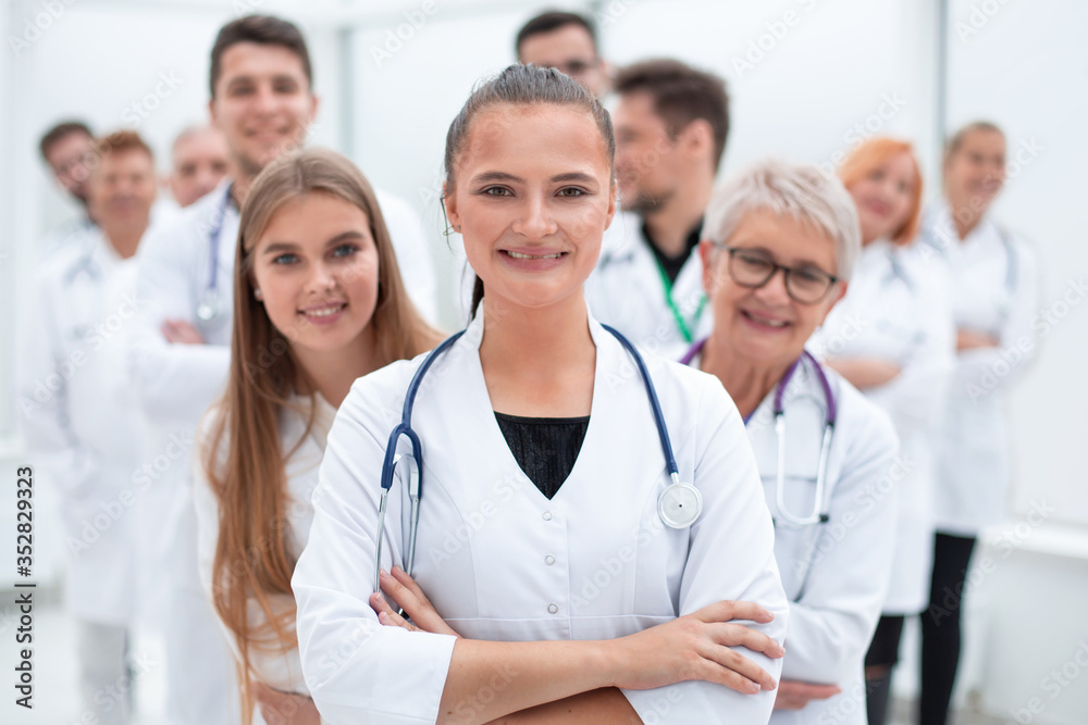 young female doctor standing in front of her older colleagues.