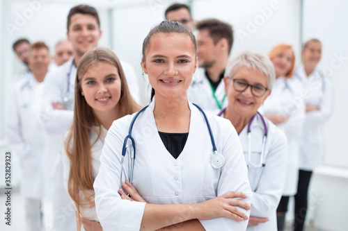 young female doctor standing in front of her older colleagues.