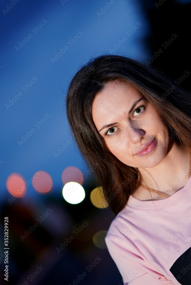Obraz premium Portrait of pretty girl in pink blouse in evenig in park