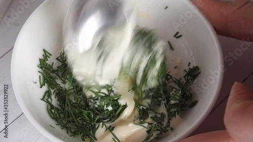 Adding finely chopped dill to the cream sauce mayonnaise. Cooking milky sauce.