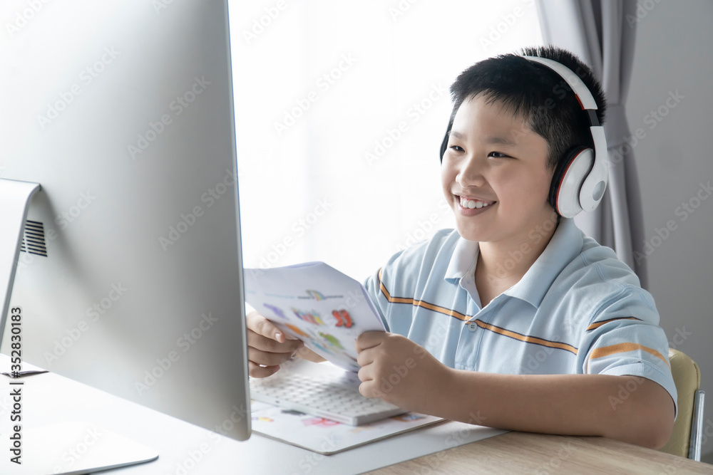 Asian Kid self isolation using computer desktop for his homework, Social Distance, E-learning online education. Asian Kid self isolation using computer desktop for his homework, Social Distance, E-learning online education.