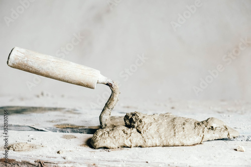 Fotografering Old used metal masonry trowel on vintage small wood bench