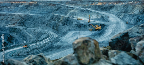 Work of trucks and the excavator in an open pit