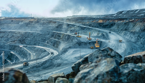 Photo Work of trucks and the excavator in an open pit