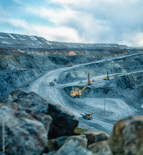 Work of trucks and the excavator in an open pit