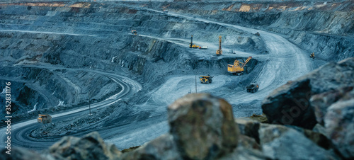 Work of trucks and the excavator in an open pit