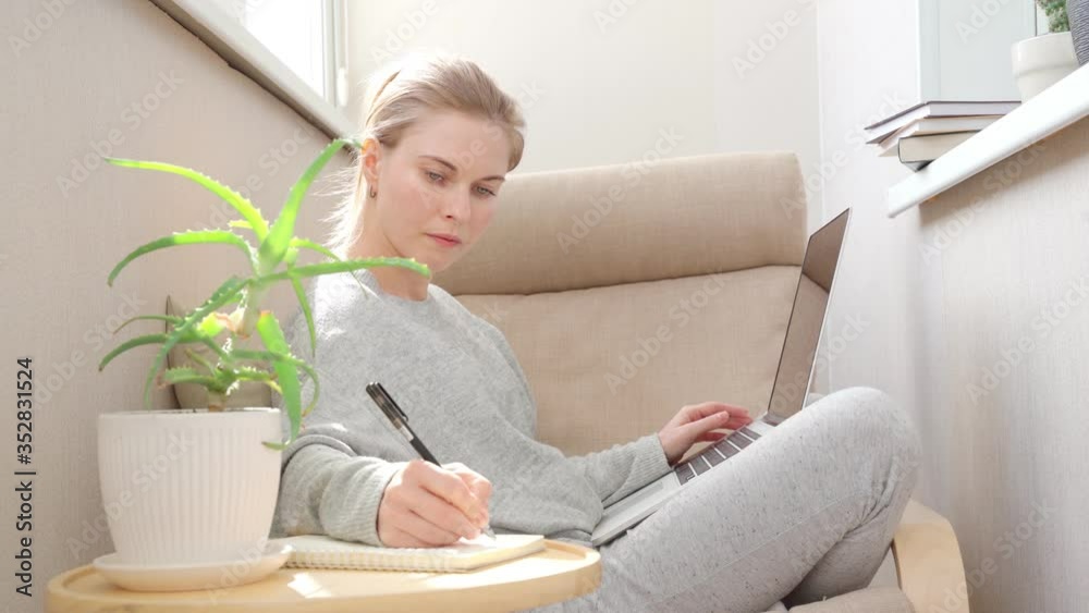 Young woman using laptop computer at small room. Young woman using laptop computer at small room.