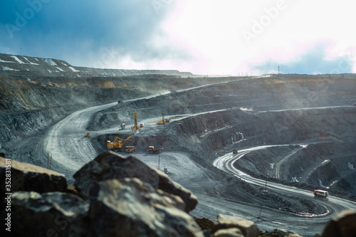 Work of trucks and the excavator in an open pit photo