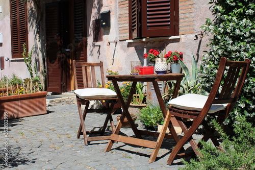 table and chairs in front of house in street 