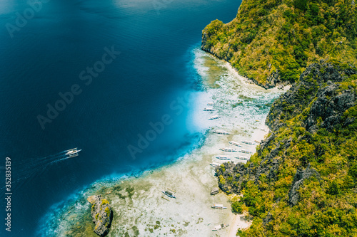 Aerial drone view of tropical Shimizu Island. Limestone coastal rocks  white sand beach in blue water. El Nido  Palawan  Philippines