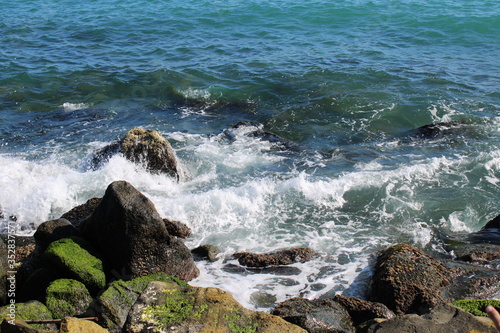 Sea water waves touching the rocks on shore 