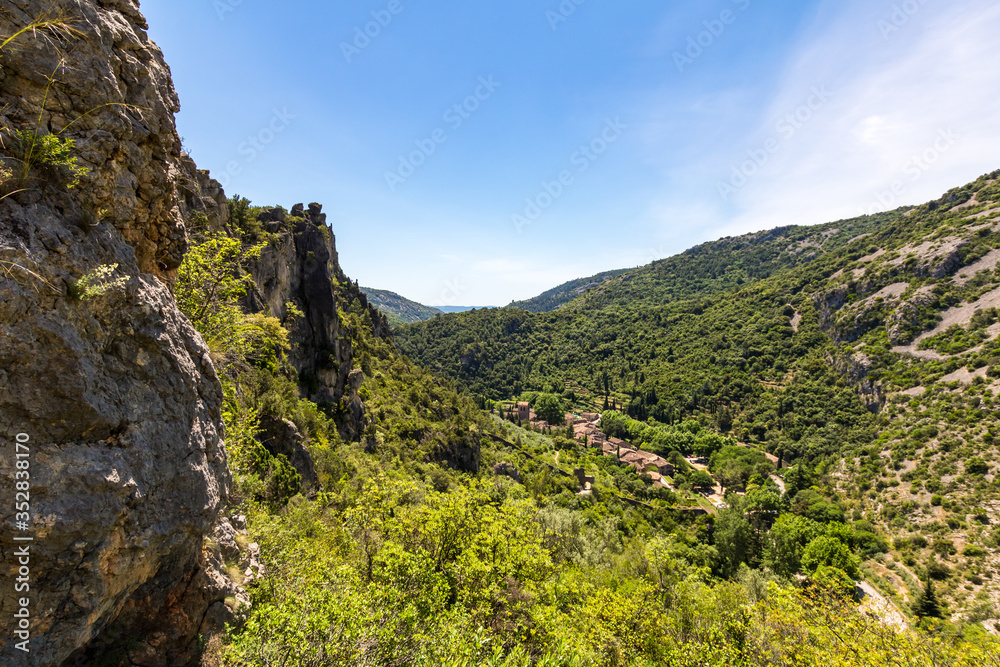 Vue sur le village médiéval de Saint-Guilhem-le-Désert au fond d'une vallée (Occitanie, France)