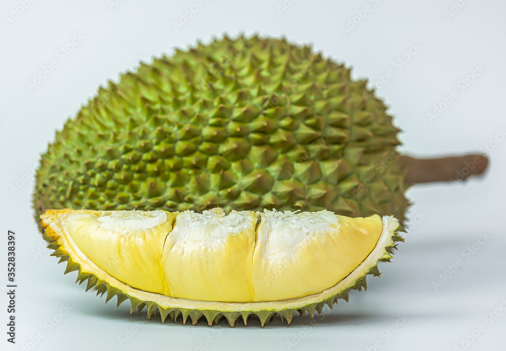 Fototapeta premium Fresh cut durian on a pastel yellow background, king of fruit from Thailand, creative food concept