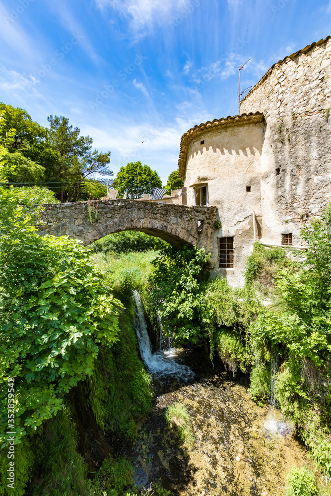 Obraz premium Cascade au coeur du village médiéval de Saint-Guilhem-le-Désert (Occitanie, France)