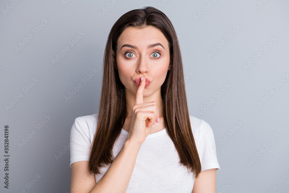 Portrait of astonished girl hear unbelievable taboo novelty put index finger lips ask dont share keep silence wear good look clothes isolated over gray color background Portrait of astonished girl hear unbelievable taboo novelty put index finger lips ask dont share keep silence wear good look clothes isolated over gray color background