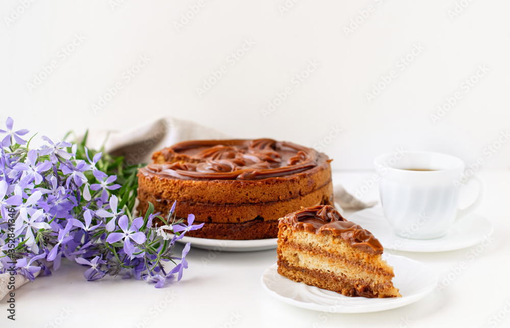 Homemade honey cake decorated with caramel on a light background. Home baking concept.