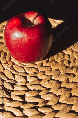 Beautiful isolated red apple illuminated on tablemats photo