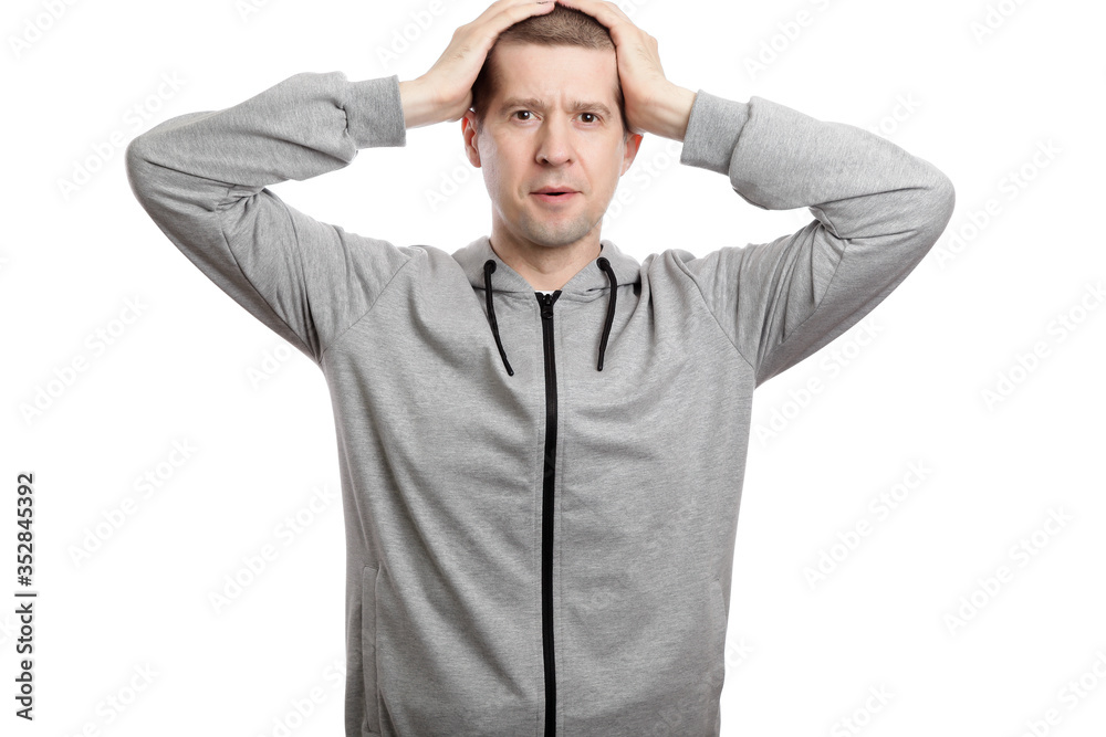 delighted man clutched his head with surprise. Dressed in sportswear. Isolated delighted man clutched his head with surprise. Dressed in sportswear. Isolated