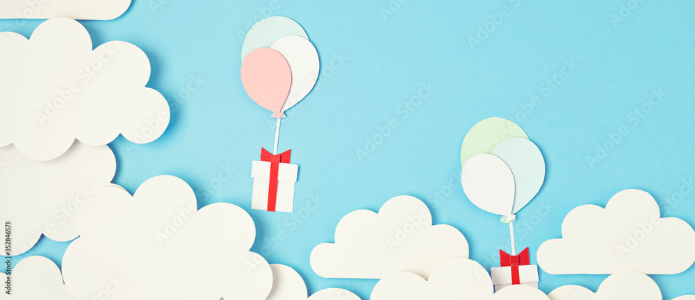 Papercut balloons and Gift Box floating in blue sky with clouds. Happy Bithday, Merry Christmas festive poster. Greeting card with paper craft