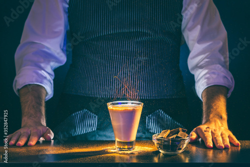 Bartender serving sparkling Baileys comet cocktail on fire