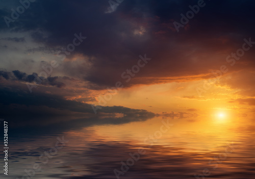 Dramatic sunset with clouds reflected in water. © Vladimir Arndt
