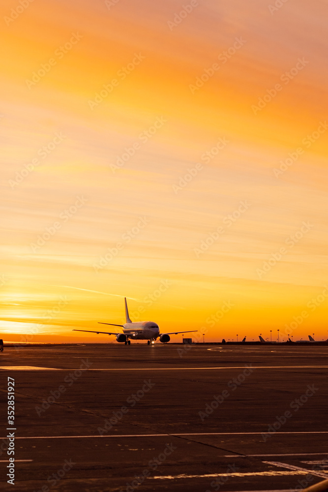 Fototapeta premium Silhouette of a plane in the airport on the dawn