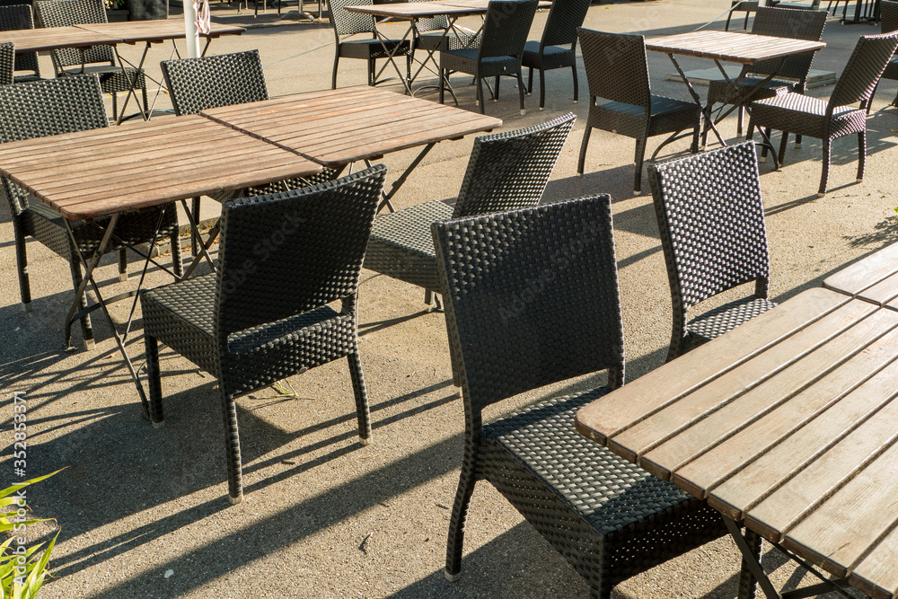 Restaurant with empty chairs and tables in the evening sun during curfew at Corona
