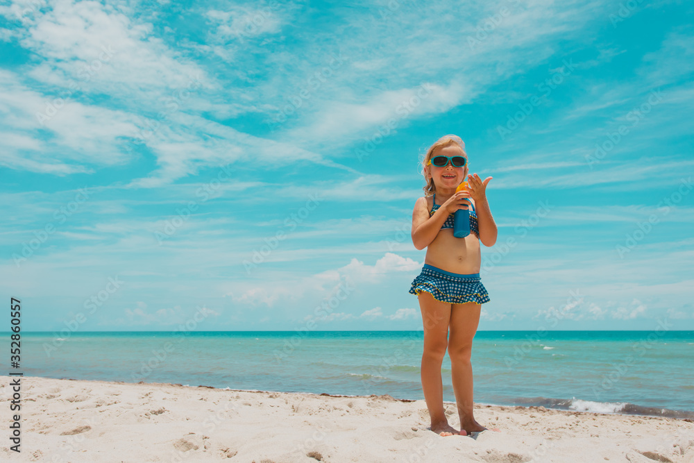 sun protection - cute little girl with suncream at beach sun protection - cute little girl with suncream at beach