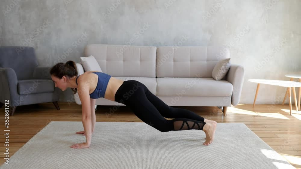 Athletic girl in sportswear pumps the abdominals. A beautiful girl does sports exercises at home in online training. Sport and fitness. Training, workout and wellness concept.