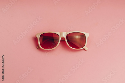 red sunglasses on a wooden background