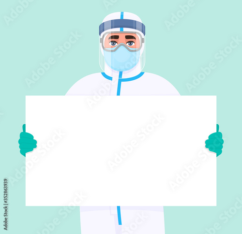 Male doctor in safety protection suit, mask, glasses and face shield showing blank poster, banner. Physician or surgeon holding empty white board. Person wearing personal protective equipment uniform.