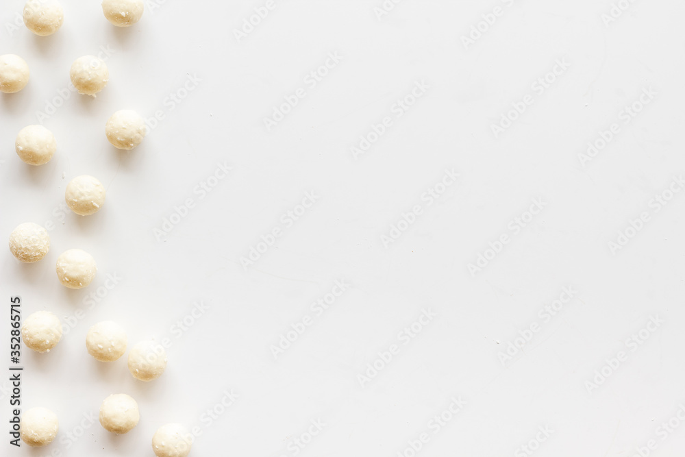 Coconut candy balls on white background top view copy space Coconut candy balls on white background top view copy space