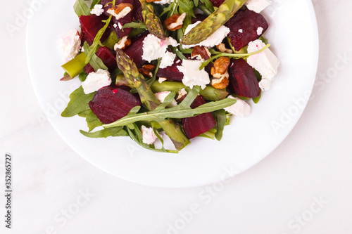 Green vegan salad with asparagus  feta  beetroot  arugula  lime and nuts