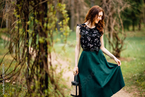 portrait of beautiful young girl in dress and with handbag in the garden, woman outdoors portrait