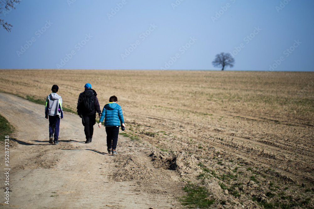 a family wandering through dry fields, through the countryside, family travels